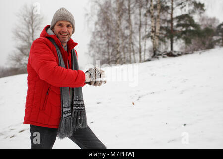 Reifer Mann das schneeball während Schneeballschlacht Stockfoto