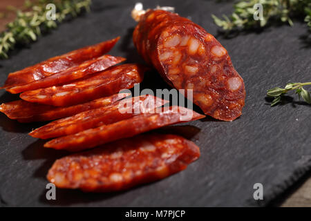 Scheiben Chorizo Wurst auf einer Schiefertafel Schneidebrett Stockfoto