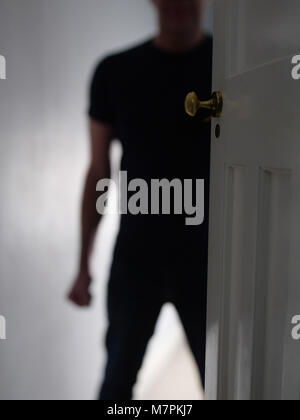Bedrohlich Mann in Türdurchgang zu Hause mit einer geballten Faust. Häusliche Gewalt. Stockfoto