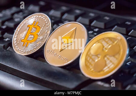 Cryptocurrency Münzen über Tastatur, Schwarz; Bitcoin, des Astraleums und Welligkeit Münzen Stockfoto