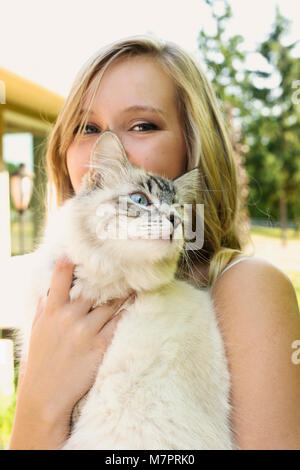 Ein teenaged Mädchen, dass eine Katze Stockfoto