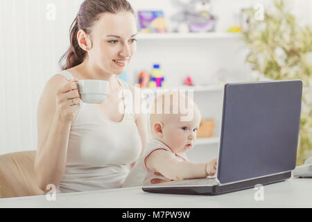 Junge Mutter und mit Laptop mit grandma über Skype kommunizieren Baby, Stockfoto