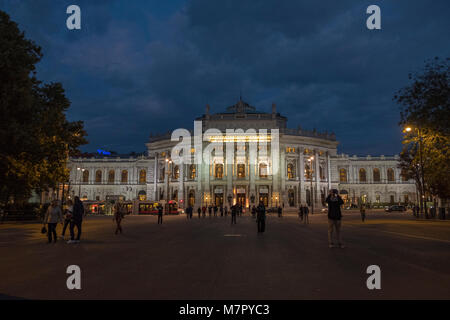 Mittellange Aufnahme des Burgtheaters in Wien auf dem Rathausplatz in Wien. In der blauen Stunde mit dem Theater leuchtet auf Stockfoto