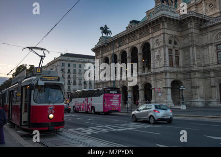 Alte Straßenbahn zieht weg von Anschlag mit der Wiener Oper hinter sich. Am frühen Abend im September getroffen, als sie die Lichter der Stadt sind auf kommenden Stockfoto