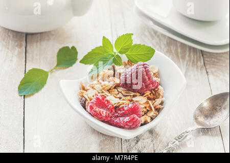 Gesundes Müsli Müsli mit Obst und Erdbeeren und Himbeeren mit Milchprodukten und Minze. Selektiver Fokus . Der Begriff der höheren Ernährung. Stockfoto