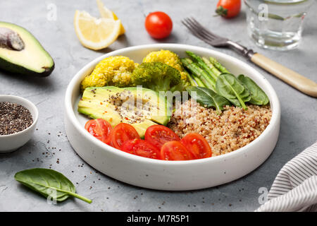 Ernährung gesundes Frühstück. Quinoa und Gemüse: Tomaten, Spargel, Brokkoli, Avocado und Spinat, Chia Samen in einer weißen Schüssel. Stockfoto
