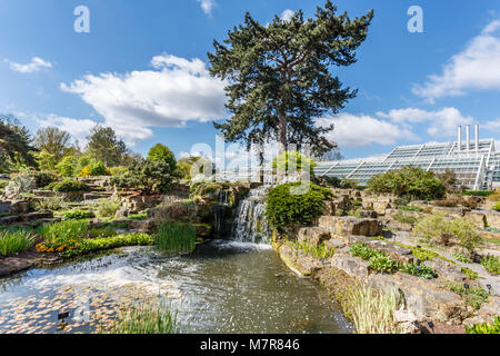 London, Großbritannien - 18 April 2014. Rock Garden und die Prinzessin von Wales Konservatorium in Kew Botanic Gardens. Die Gärten wurden 1840 gegründet. Stockfoto