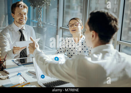 Lächelnd executive Übergabe Dokumente zu seinem Kollegen Stockfoto