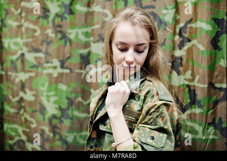 Militärische Mädchen in der Tarnung Uniform gegen Armee Hintergrund. Stockfoto