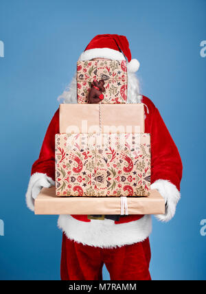 Santa Claus holding Stack der Weihnachtsgeschenke Stockfoto