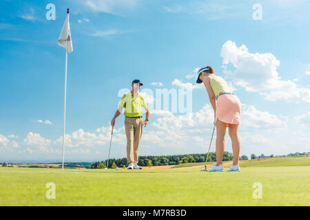 Weibliche Golf Spieler bereit, den Ball zu schlagen Stockfoto