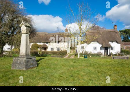 Charmante reetgedeckte Cottages in Martin Dorf in Hampshire, Großbritannien, mit dem Village Green und Replika 2000 Dorf Kreuz Stockfoto