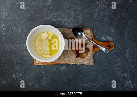 Hühnerbrühe mit hausgemachten Nudeln, Brot und Wachteleier. Stockfoto