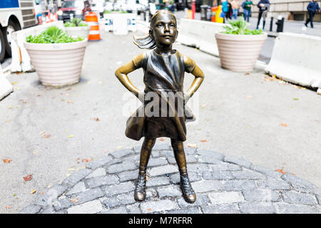 New York City, USA - 30. Oktober 2017: Wall Street Börse Der Furchtlose Mädchen Statue vor wütenden Stier Metall in NYC Manhattan geringere finanzielle Stockfoto