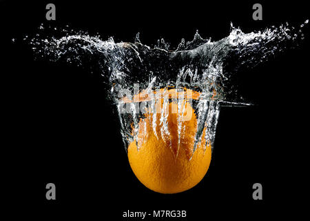 Frische orange mit Wasser spritzen auf schwarzem Hintergrund Stockfoto