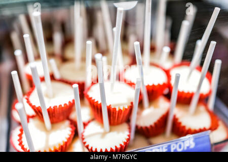 Nahaufnahme von weißer Schokolade Kuchen pops lollipos auf Sticks in Rot muffin Papier Büchsen auf Anzeige in Candy Store shop Becher Trüffel Stockfoto