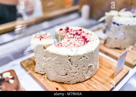 Makro Nahaufnahme des großen Ganzen süßen Sesam halvah Einfügen tahini im Mittleren Osten Markt mit rosa rot weiße Schokolade Stockfoto