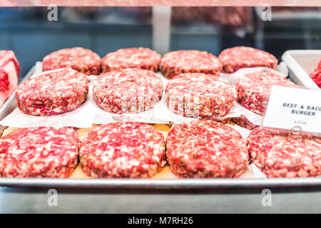 Viele Rindfleisch und Speck Burger rohes Fleisch Würstchenpastete auf Tray mit rosa Chunks in butcher shop Stockfoto