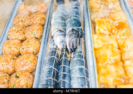 Nahaufnahme von viele Heringe Fisch ganz Augen Plastik eingewickelt, Kuchen Burger in Seafood Market Anzeige Stockfoto