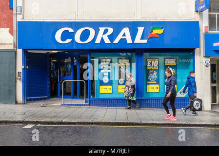 Menschen zu Fuß vorbei an einer Koralle Buchmacher/Wetten shop Fassade an der High Street in Southampton, Southampton, England, Grossbritannien Stockfoto