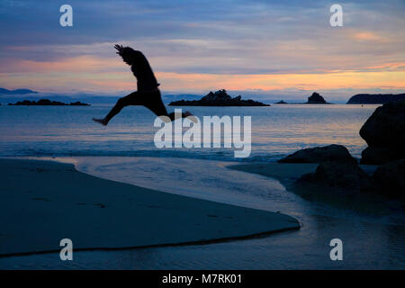 Junge springen Stream bei Dämmerung, Mosquito Bay, Abel Tasman National Park, Nelson, Südinsel, Neuseeland Stockfoto