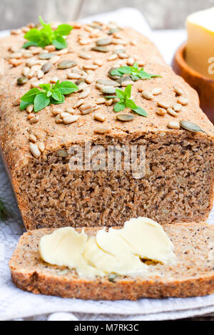 Hausgemachte Scheiben Schwarzbrot mit Sonnenblumenkernen und frische Butter Stockfoto