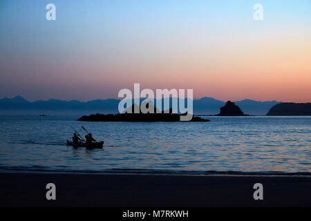 Kajakfahrer bei Dämmerung, Mosquito Bay, Abel Tasman National Park, Nelson, Südinsel, Neuseeland Stockfoto
