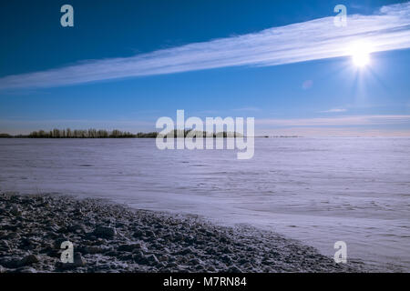 Schönen Sonnenuntergang aufgenommen in eine dramatische Wolken über einem schneebedeckten Feld Stockfoto