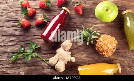 Obst und Saft Smoothie auf Holz- Hintergrund. Ansicht von oben. Healhty Ernährung und Entgiftung Konzept. Stockfoto