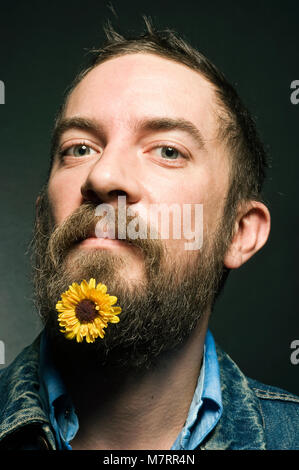 Ein Mann mit einer Blume in seinen Bart. Stockfoto