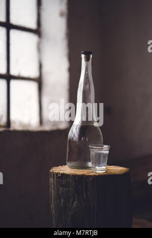 Starken Alkohol in der Flasche mit Glas in traditionellen, rustikalen Retro getönten Atmosphäre Stockfoto