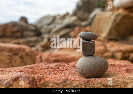 Drei Steine in einem Stapel nahe dem Meer am Strand. ideologische Konzept. Stockfoto