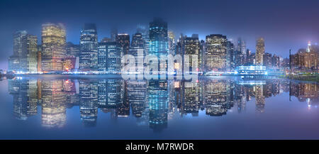 Die New York City Skyline bei Nacht. Über den East River nach Brooklyn Bridge Park fotografiert. Stockfoto