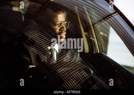 Vorderansicht des Schönen afrikanischen Elegante ernster Mann fährt Auto Stockfoto