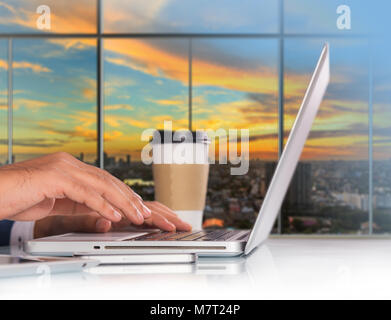 Unternehmer Arbeiten am Laptop im Büro Arbeitsplatz mit Mobile Smartphone und Kaffee auf Office Tabelle Stockfoto