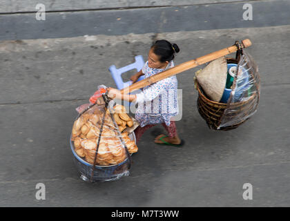 SAIGON, VIETNAM, Dec 13 2017, Frau überträgt die volle Korb mit frischen Lebensmitteln in den Straßen von Saigon. Stockfoto