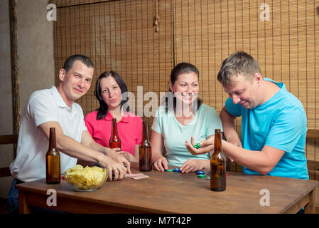Gerne vier Freunde beim Poker Spielen am Tisch und Bier trinken. Stockfoto