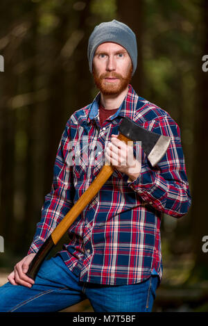 Bärtigen Holzfäller mit Axt im Wald posing Stockfoto