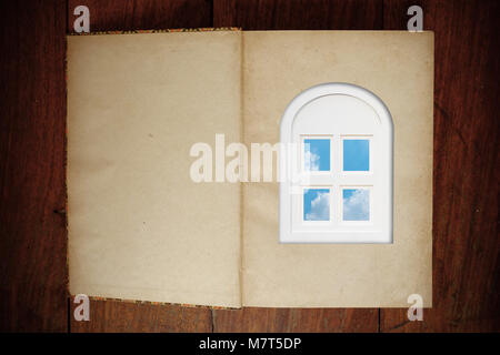 Alten grunge leere Seite Papier Buch auf holztisch und ein Fenster auf der ersten Seite geöffnet. Helle sommer himmel in das Fenster. Für das Lesen von Büchern ist Stockfoto