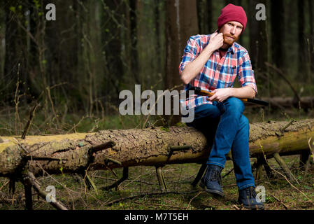 Ein Holzfäller im Wald auf einem Baum Stockfoto