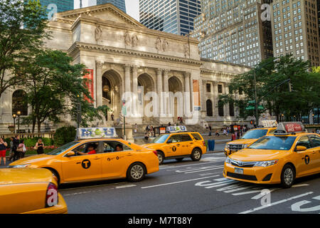 Gelb New York Taxis fahren hinter der New York Public Library auf der Fifth Avenue, Manhattan, New York City Stockfoto