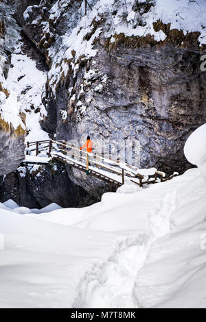 Mann, der auf der Treppe in den gefrorenen Schnee bedeckte Schlucht Baerenschuetzklamm im Winter Stockfoto