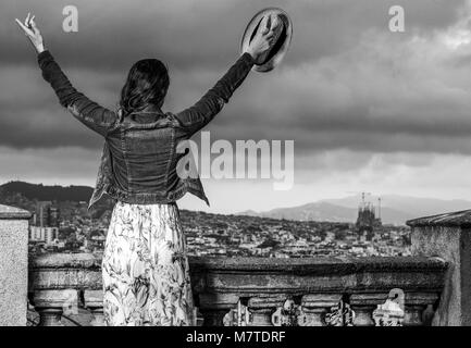 Perfekte Abend mit herrlichen Blick. Hinter der eleganten touristischen Frau im langen Kleid und Strohhut in der Stadt Panorama von Barcelona, Spa gesehen Stockfoto