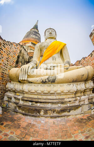 Unter Blick auf die weissen Budha mit einem gelben Stoff um seinen Körper in Sukhothai Historical Park die alte Stadt von Thailand Buddha Statue im Wat Mahathat in Sukhothai Historical Park, Thailand Stockfoto