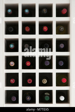 Kopf auf Foto von Holz- Integrierte Wine Rack voller Flaschen mit bunten Mützen. Stockfoto