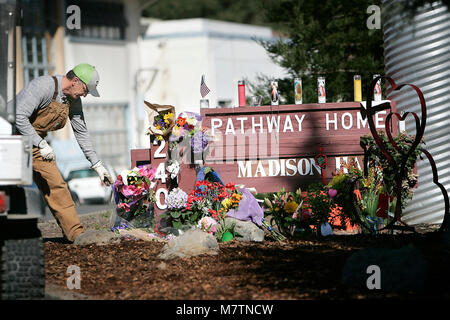 März 12, 2018 - Yountville, CA, US-Veteranen Home von Kalifornien in Yountville führen groundskeeper Mike Chiurco räumt um das Denkmal, das in der Nähe von Madison Hall nach dem tragischen shootings an den Weg nach Hause am Freitag entsprungen ist. Er schuf die Skulptur auf der rechten Seite gesehen, als er kam am Montag zu arbeiten, um die Opfer zu ehren. (Bild: © Napa Senke-Register über ZUMA Draht) Stockfoto