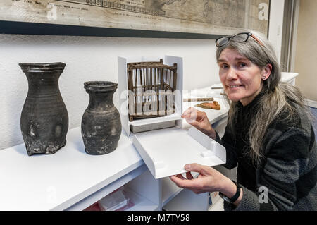 12 März 2018, Deutschland, Lübeck: Ein archäologe Doris Muehrenberg zeigt eine Vögel chage aus dem 14. Jahrhundert neben zwei Lübecker Krüge aus dem 13. Jahrhundert. Diese Funde aus der Hansestadt ist mit der Ausstellung "Bewegte Zeiten, Archaeologie in Deutschland" (Lit. turbulente Zeiten, Archäologie in Deutschland) angezeigt werden. Die Ausstellung im Martin-Gropius-Bau in Berlin vom 21. September 2018 bis zum 06. Januar 2019 besucht werden. Foto: Markus Scholz/dpa Stockfoto