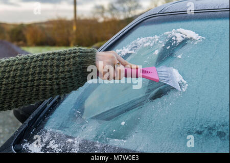 Ballydehob, Irland. 13.. März 2018. Eine Frau taut die Windschutzscheibe ihres Autos nach einer schweren Frostnacht auf. Nach einem trockenen und hellen Morgen wird die Wolke allmählich zunehmen, was Ausbrüche von Regen und Nieselregen heute Nachmittag zur Folge hat. Kredit: AG News/Alamy Live News. Stockfoto