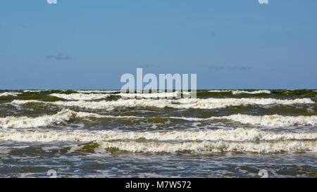 Dunkelbraun Wellen der Ostsee an einem sonnigen Tag mit blauen Himmel Stockfoto