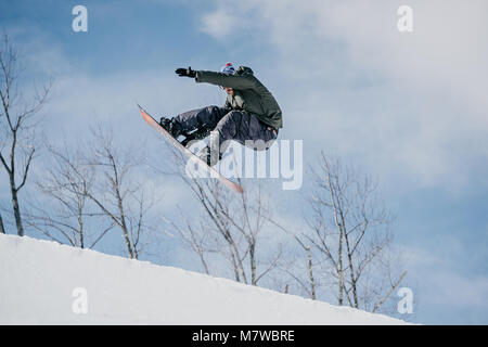 Snowboarder springen auf Halfpipe Stockfoto